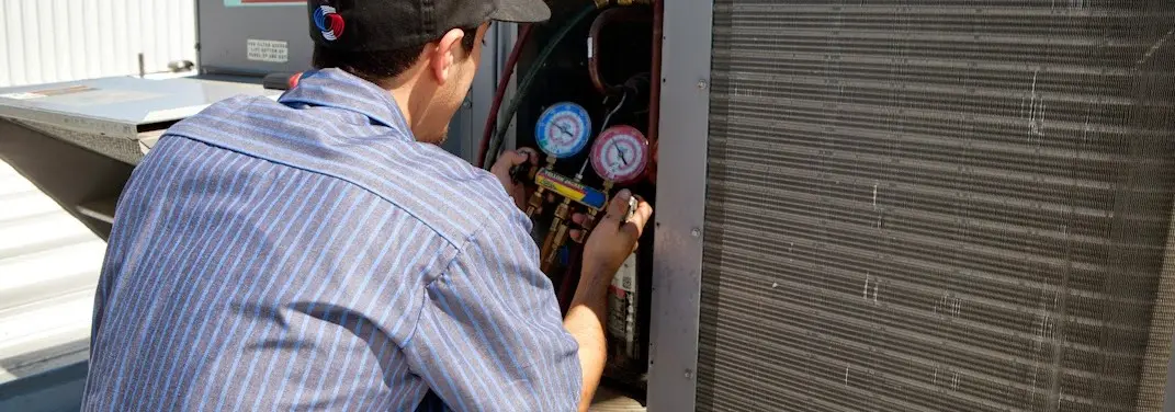 HVAC technician servicing a condenser unit in Mendham