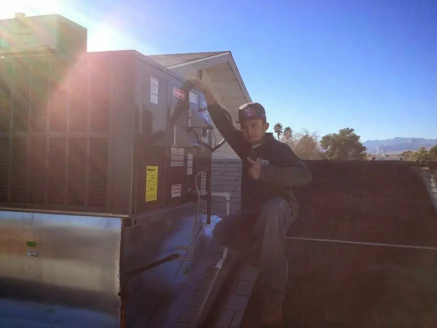 HVAC technician performing AC Tune-Up on a rooftop unit in Mendham